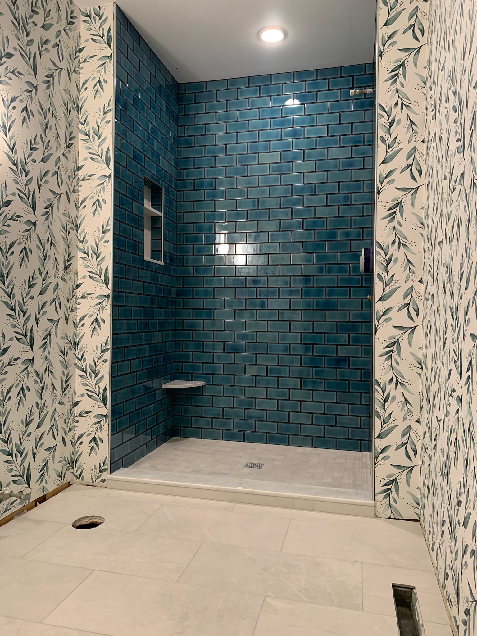 blue bathroom tile with floral wallpaper